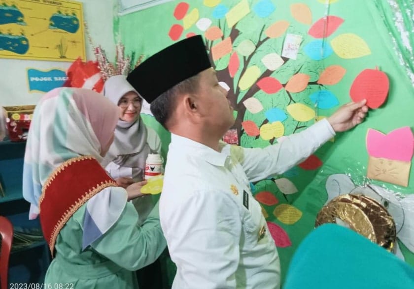 Pj.Bupati Barsel H. Deddy Winarwan dan Bunda PAUD Kab.Barsel Hj. Erna Ardiani turut bersama anak-anak PAUD Kaharapen Rama Desa Mbuan mengisi pohon harapan (foto:HN2R) 